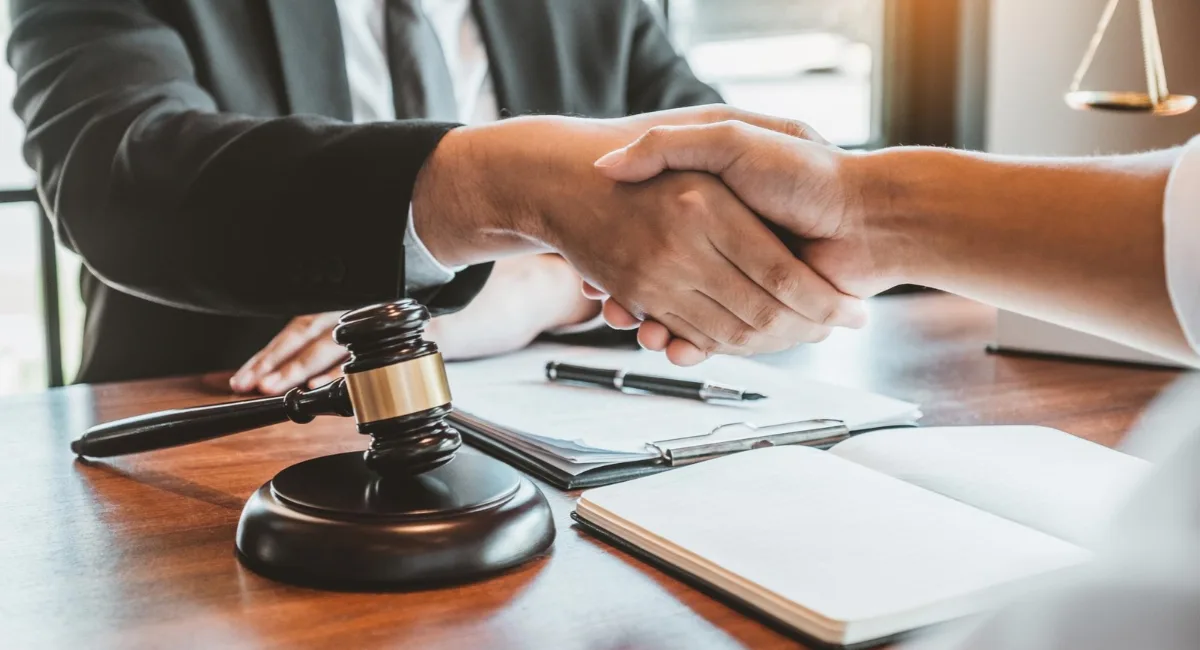 Arbitration in corporate disputes with a business handshake and legal gavel